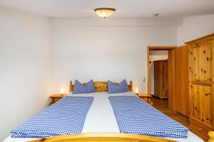 a bedroom with a blue and white bed with two candles at Fewo Brünnstein - Zimmer 65 in Oberaudorf