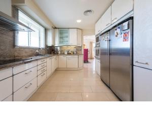 a kitchen with white cabinets and a stainless steel refrigerator at Chalet en la playa San Agustin in Maspalomas