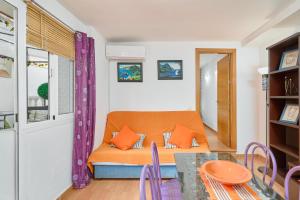 a living room with an orange couch and a table at Naranja apartment in Nerja