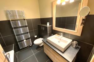 a bathroom with a sink and a toilet and a mirror at Les Craterelles 3 - 1650 in Courchevel +15 photos