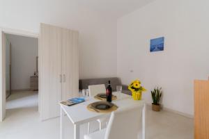 a white dining room with a white table and chairs at Casa Elaia 4 posti a Cannole in Cannole