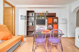 a dining room with purple chairs and a table at Naranja apartment in Nerja