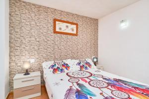 a bedroom with a bed with a colorful comforter at Naranja apartment in Nerja