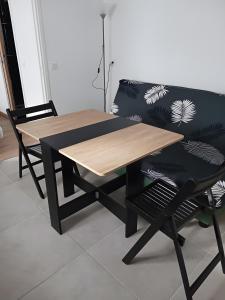 a wooden table and two chairs and a couch at Chalet proche dinard in Pleurtuit
