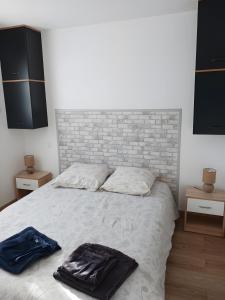a bedroom with a bed with a brick wall at Chalet proche dinard in Pleurtuit