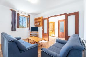 a living room with two blue couches and a table at Casa del Practicant in Culla