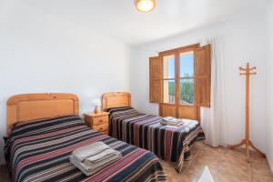 two beds in a room with a cross on the wall at Casa del Practicant in Culla