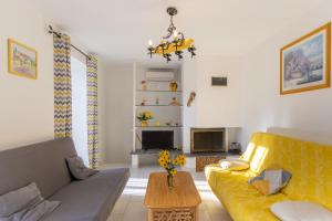 a living room with a yellow couch and a table at Chez l'Oncle in Gras
