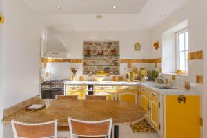 a kitchen with yellow cabinets and a wooden table at Chez l'Oncle in Gras