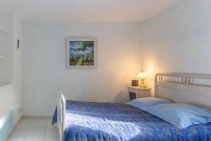 a bedroom with a bed and a picture on the wall at Chez l'Oncle in Gras