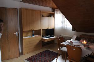 a living room with a table and a television at Gästehaus Heimenberg in Bad Rippoldsau-Schapbach