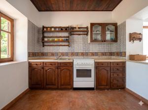 a kitchen with wooden cabinets and a white stove top oven at Мечта in Kruče