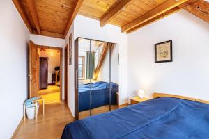 a bedroom with a blue bed and a mirror at Ole Schün Dannau in Oldenburg in Holstein