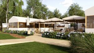 a patio with umbrellas and tables and a building at Eco Camping in Spytkowice