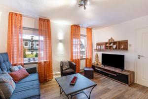 a living room with a blue couch and a tv at Ferienwohnung Holterhoff in Olpe