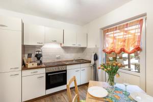 a kitchen with white cabinets and a table and a window at Ferienwohnung Holterhoff in Olpe