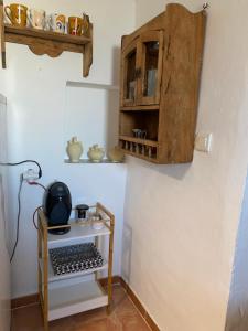 a kitchen with a wooden cabinet hanging on the wall at Casa Nora in Iznate +5 photos