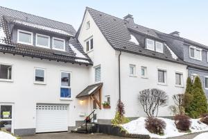 a white house with a black roof at Ferienwohnung Holterhoff in Olpe