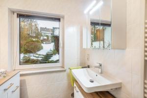 a bathroom with a sink and a window at Ferienwohnung Holterhoff in Olpe +12 photos