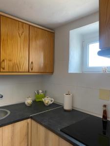 a kitchen with wooden cabinets and a black counter top at Casa Nora in Iznate