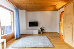 a living room with a television and a large window at Haus Simon in Nova Levante
