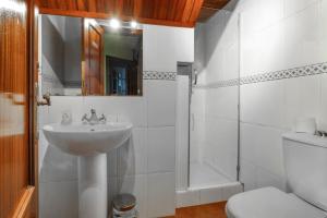 a white bathroom with a sink and a shower at Angela in Isla +20 photos