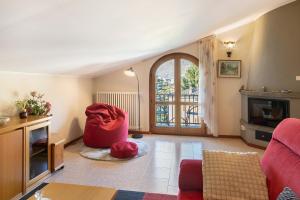 a living room with a red couch and a fireplace at Casa Vacanze Dal Castelin in Sondrio