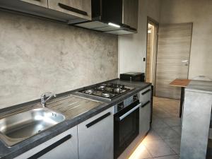 a kitchen with a sink and a stove top oven at DeMarchi in Biella