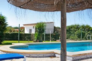 a swimming pool with an umbrella and a table and chairs at Villa Perez Zara Paco in Campano