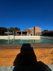 a shadow of a person standing in front of a swimming pool at Casa Subiraneta in Puigreig