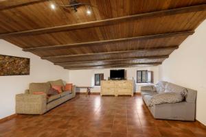 a living room with two couches and a tv at Casa Subiraneta in Puigreig