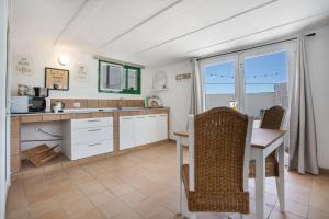 a kitchen with a desk and a table and chairs at Piscina Climatizada in La Hidalga