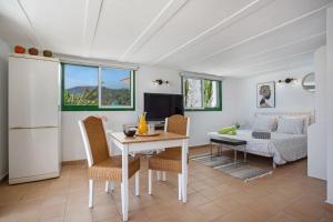 a living room with a table and chairs and a couch at Piscina Climatizada in La Hidalga