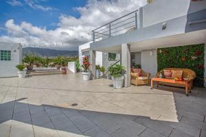 a patio with furniture and plants on a house at Piscina Climatizada in La Hidalga