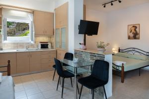 a kitchen and dining room with a table and chairs at Gorgona 1 in Loutra +17 photos