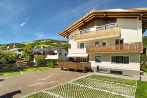 a large white building with a balcony and a yard at Premium App Hofer Maria in Villabassa
