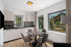 a kitchen with a table and chairs and a window at Premium App Hofer Maria in Villabassa
