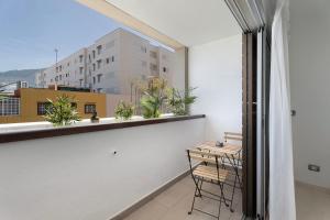 a balcony with a table and chairs and a window at Apartamento Opuntia in La Orotava