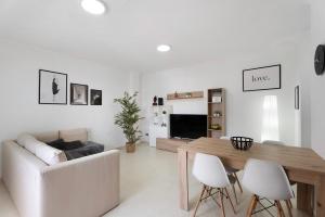 a white living room with a table and a couch at Apartamento Opuntia in La Orotava