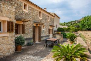 a stone house with a table and chairs outside at Els Clepes in Son Servera