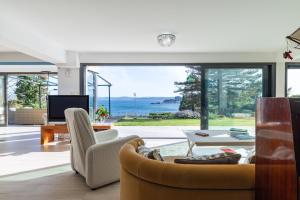 a living room with a view of the ocean at El Chiripero Beach Villa in A Coruña