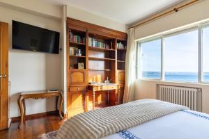 a bedroom with a bed and a desk and a window at El Chiripero Beach Villa in A Coruña
