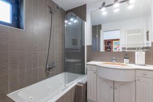 a bathroom with a tub and a sink and a shower at El Chiripero Beach Villa in A Coruña +31 photos