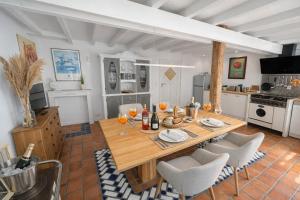 a kitchen and dining room with a wooden table and chairs at Huus ant Kornfeld Erdgeschoss in Osteel