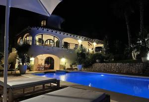 a villa with a swimming pool at night at Villa Torre in Jávea