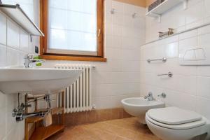a white bathroom with a sink and a toilet at Residence Larice Bianco App n3 in Campodolcino +19 photos