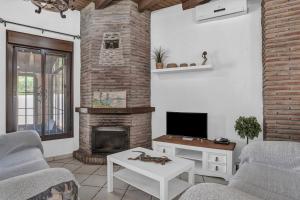 a living room with a fireplace and a tv at Casas al Alba in Zahora