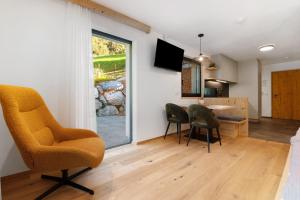a living room with chairs and a table and a window at Mountain Chalet Tribulaun Pflersch in Colle Isarco
