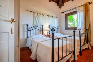 a bedroom with two beds and a window at Villa Sa Pintadera private pool in Stintino