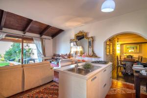 a kitchen and living room with a sink and a couch at Villa Sa Pintadera private pool in Stintino